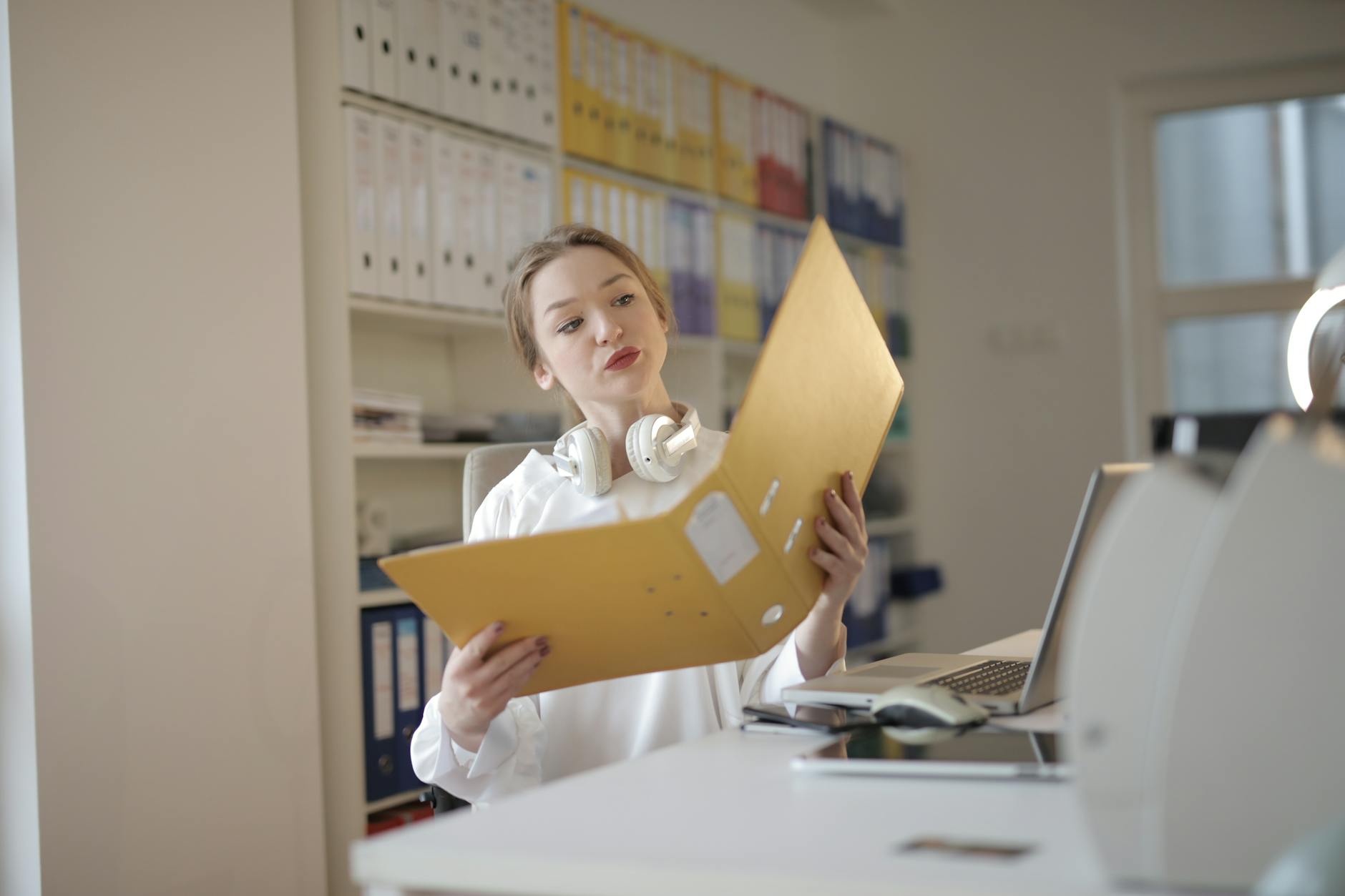 thoughtful female office worker with folder in workplace